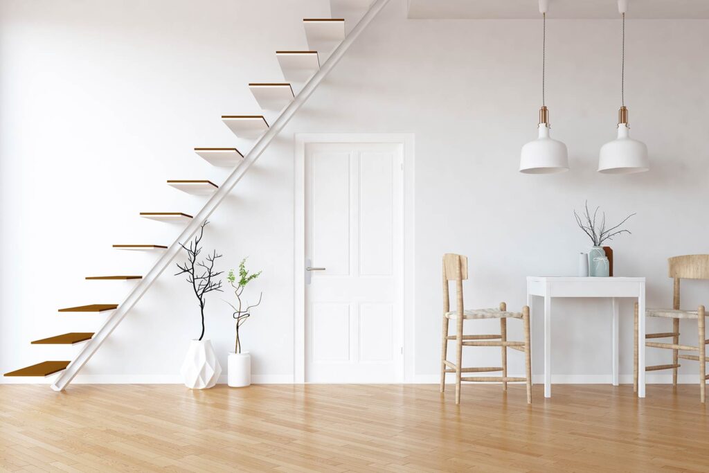 Idee eines weißen skandinavischen Küchenraums Inneneinrichtung mit Essmöbeln und Treppen, Tür und große Wand und weiße Landschaft im Fenster.